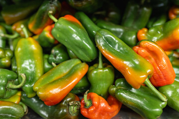 Colorful green and red bell peppers stacked at market