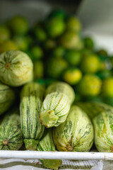 Striped zucchinis stacked at a market or grocery store