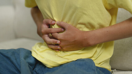 Asian man has stomach ache.