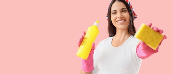 Beautiful housewife with cleaning sponge and detergent on pink background with space for text
