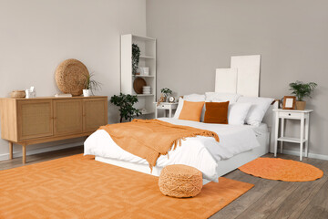 Interior of stylish bedroom with bed, bedside tables and chest of drawers