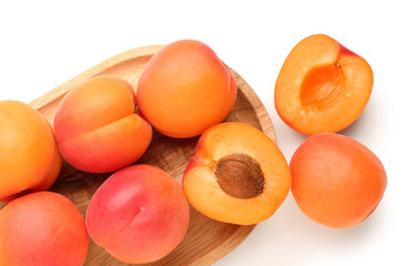 Wooden board with ripe apricots isolated on white background