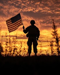 Silhouette of soldier holding American flag at sunset