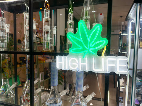 Hua Hin, Thailand - June 14, 2025: Cannabis Themed Shop Display with Neon High Life Sign and Glass Bongs for Sale