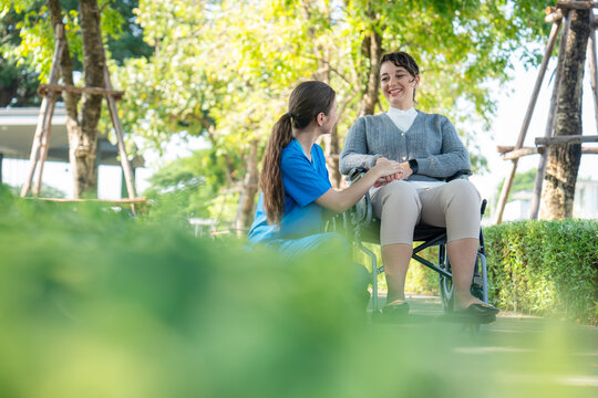 Nurse and elderly woman sitting on grass, enjoying peaceful and compassionate moment together in home care setting.