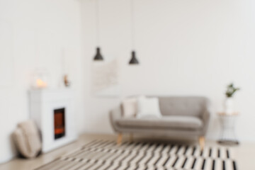 Blurred view of stylish living room with fireplace and comfortable sofa