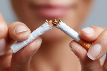 Unrecognizable young woman breaking a cigarette in half to stop smoking