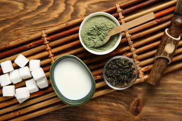 Composition with matcha tea, ingredients and accessories on wooden background, closeup