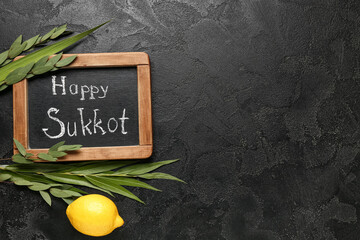 Four species (lulav, hadas, arava, etrog) and chalkboard with text HAPPY SUKKOT on black grunge...
