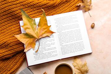 Composition with open book, clothes and fallen leaves on color background