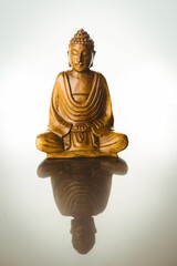 Buddha statue with reflection on table