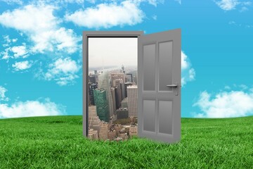 Door and cityscape on grassy landscape against sky
