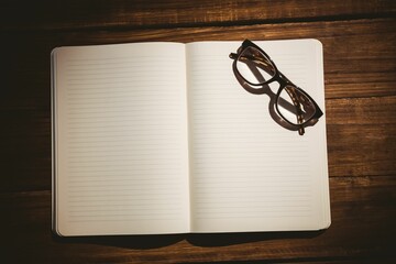 Eyeglasses on book at desk
