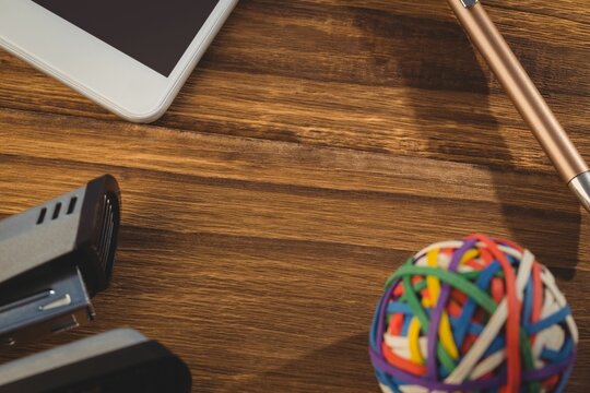 Rubber band ball with stapler on wooden table
