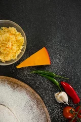 Gordijnen Cheese by spices on black table © vectorfusionart