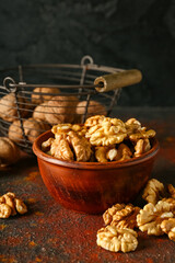 Bowl of tasty walnuts on table
