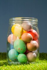 Easter eggs in glass jar on grassy field