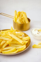 Plate of tasty french fries on white background
