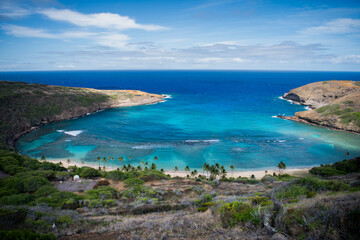A scenic view of Hanauma Bay on the island of Oʻahu, Hawaii, showcasing the clear turquoise waters, coral reef, and lush coastal surroundings of this iconic natural preserve.