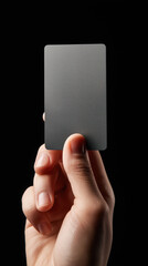 Hand holding blank unbranded modern gray card on dark background