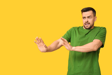 Handsome ashamed young man on yellow background