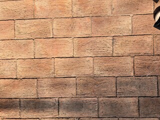 Textured reddish-brown brick wall with horizontal pattern