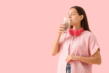 Young woman drinking chia seed water on pink background