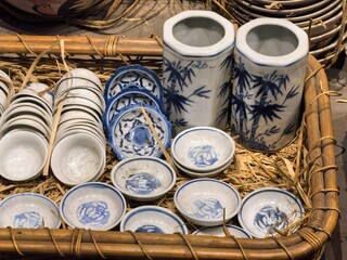 Traditional blue and white ceramic pottery in a rustic basket.