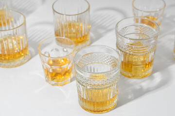 Glasses of cold rum on white background