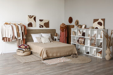 Rack with clothes, mannequin and shelving unit in interior of modern bedroom