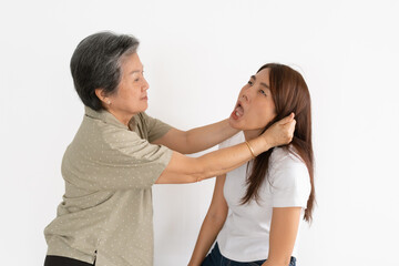 Fuuny Asian Thai senior woman squeezing young woman's ears, scolding isolated over white wall.