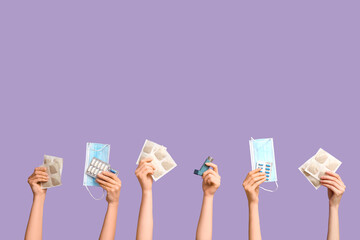 Female hands with mustard plasters, inhaler, medical masks and pills on purple background