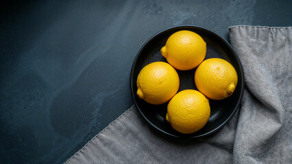 Fresh lemons juicy yellow citrus fruit on dark plate