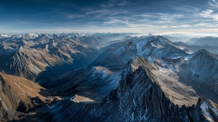 Majestic mountain range under clear blue sky with expansive cloudscape