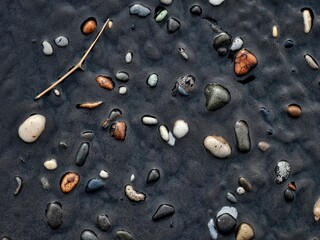 Smooth stones embedded in dark mud