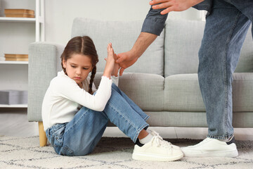 Father threatening his daughter at home. Domestic violence concept