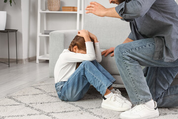 Father threatening his daughter at home. Domestic violence concept