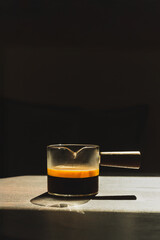 Espresso coffee in a glass cup on a dark background in vertical.
