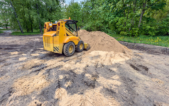 earthmoving machine is leveling the construction site. mini-loader prepares the site for construction works.