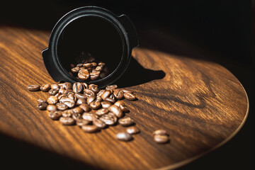 Close up roasted coffee beans on wooden table with sunlight.