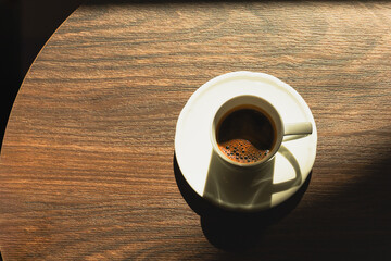 espresso in a cup on a wooden table top view.