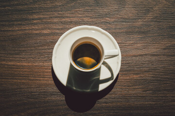 Espresso in a cup on a wooden table top view.