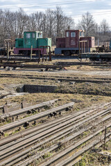 Abandoned narrow gauge railway locomotives and rusty rails lying on the ground in Csomoder, Hungary