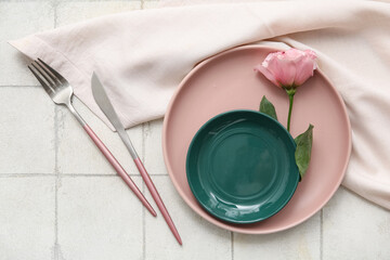 Stylish table setting with beautiful pink flower on white tile background