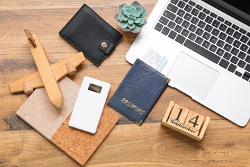 Traveler's items with laptop and power bank on wooden background