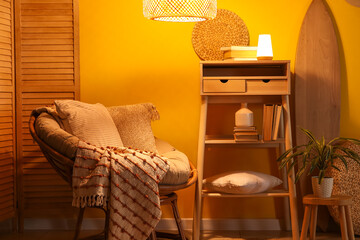 Interior of dark living room with armchair, table and glowing lamps