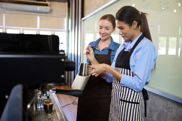 female baristas making fresh coffee from machine in the cafe