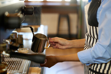 close up barista hands making fresh coffee from machine in the cafe