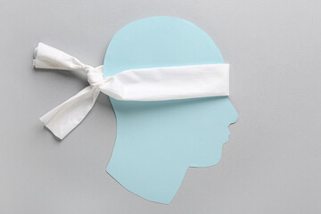 Paper human head with blindfold on grey background. Concept of oppression