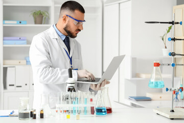 Male scientist working with laptop in laboratory